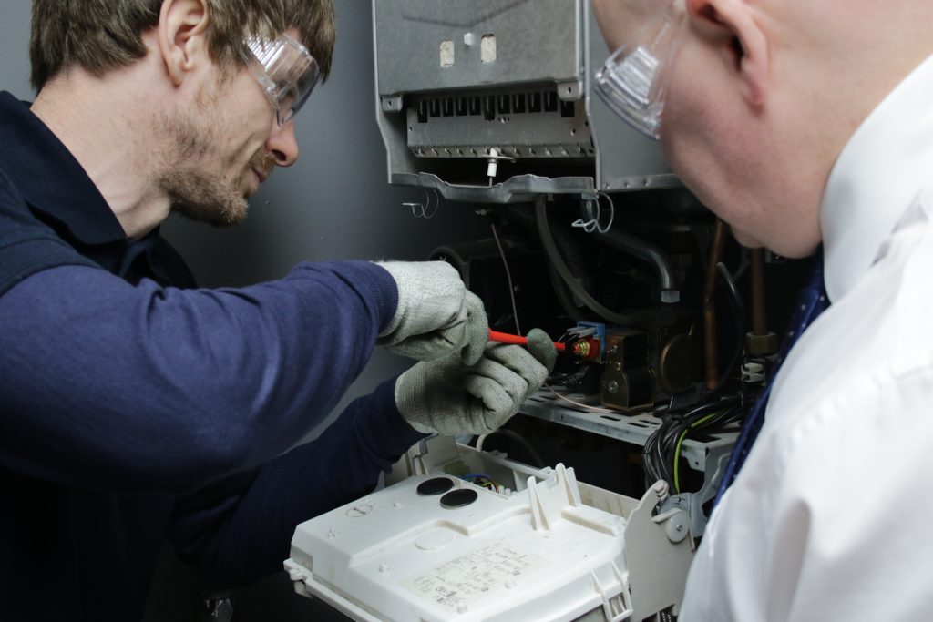 Craig training a student on a gas boiler