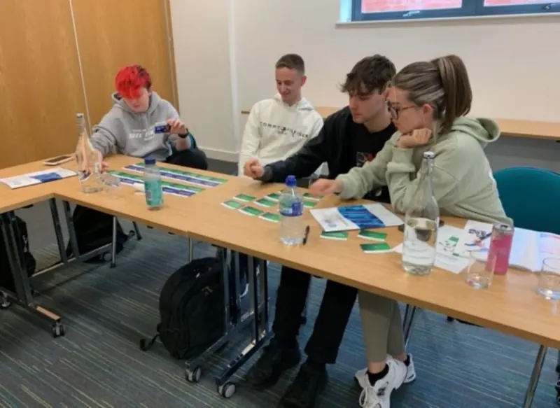 Learners working together with training cards during a first aid classroom activity
