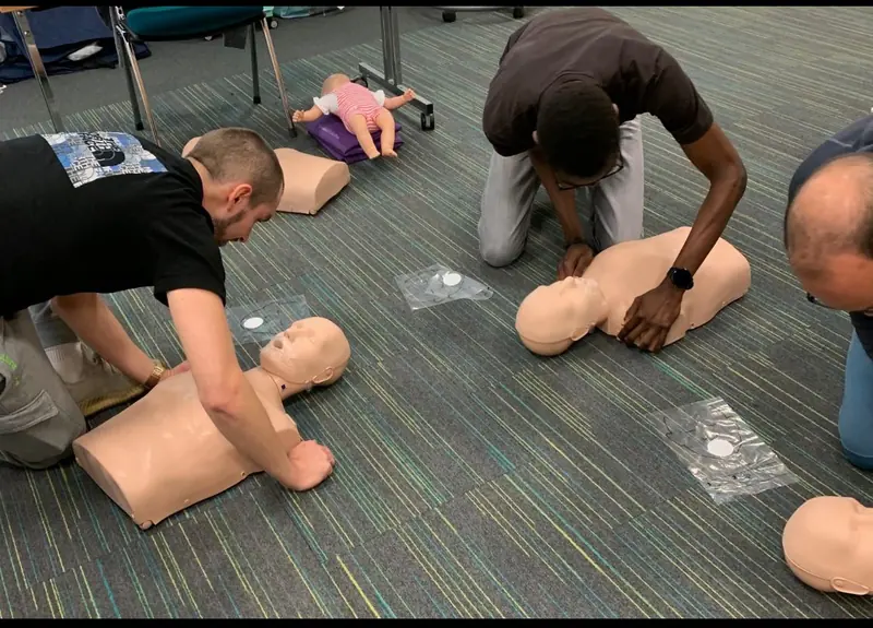 Learners practising CPR on adult manikins during first aid training