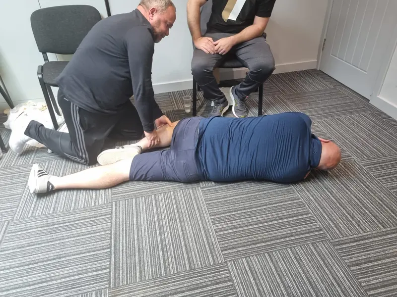 A learner practising the recovery position with another participant
